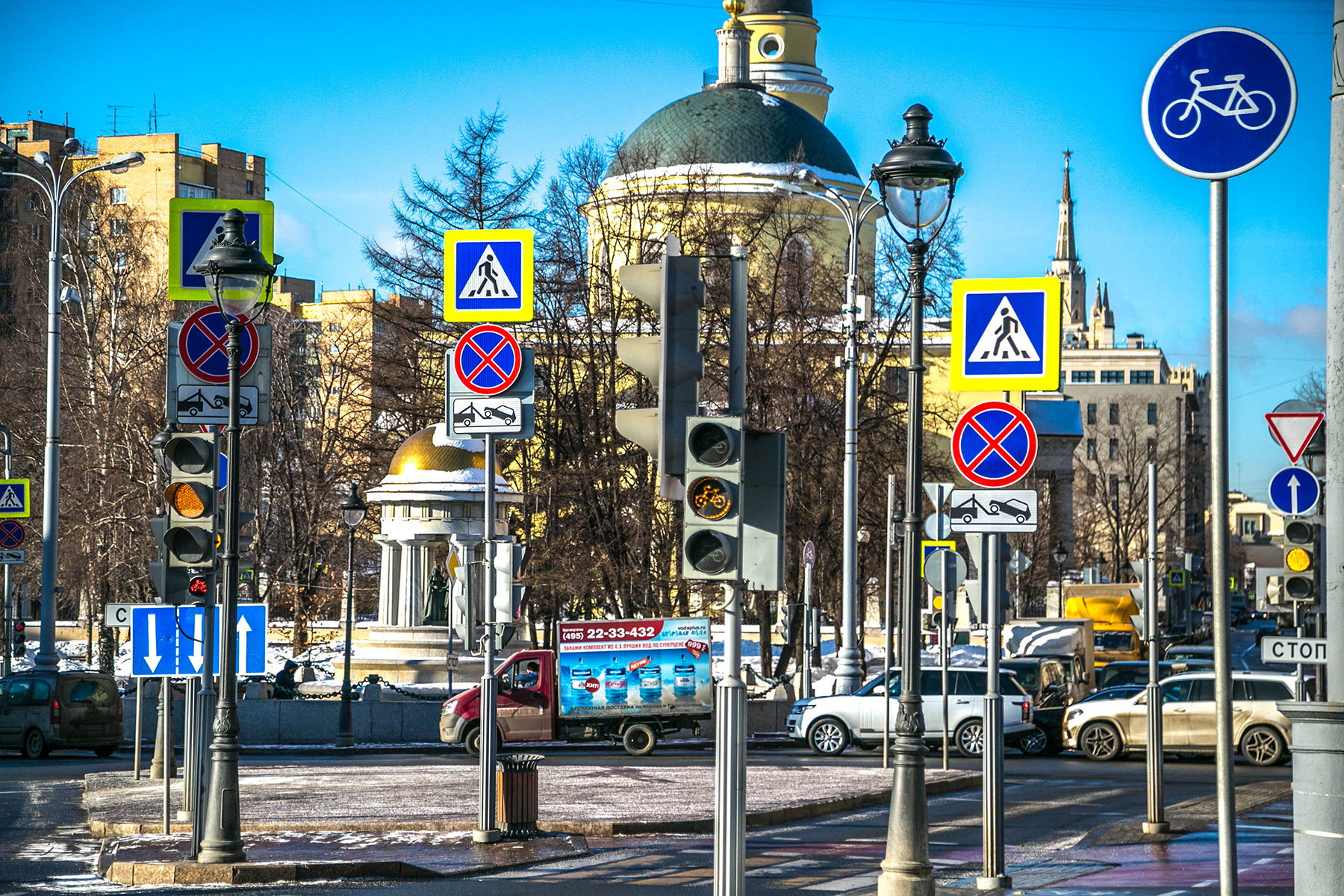 Дорожное движение в городе. Дорожные знаки на улицах города. Светофор на улице города. Знаки на улице города.